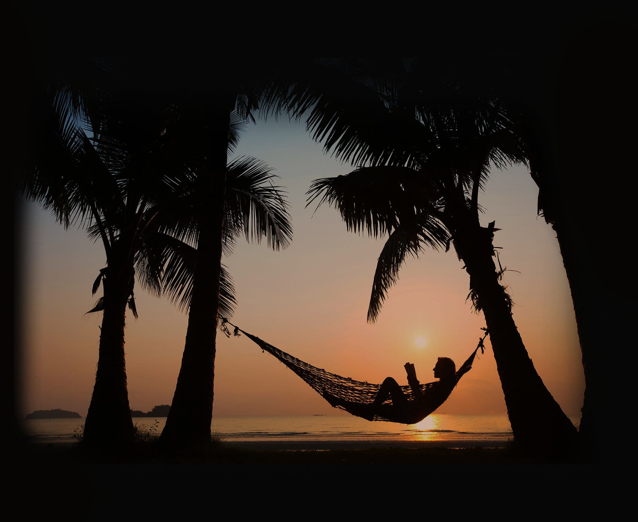 Child reading book under sunset
